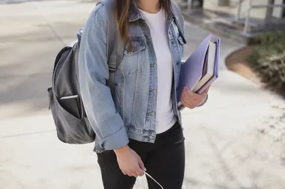 Campus Student Carrying Bible in Backpack