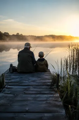 Grandfather and Boy Fishing at Sunrise