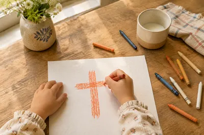 Child Drawing a Cross with Crayons