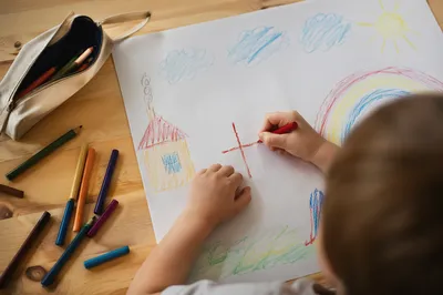 Child Drawing Cross With Colorful Crayons