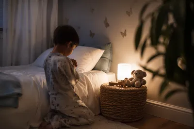 Child Praying Beside Bed at Night