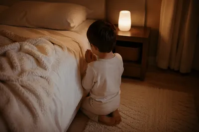 Child Praying Beside Bed at Night