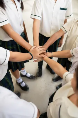 Children Stacking Hands in School Teamwork Circle