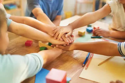Children Hands Stacked in Teamwork Circle