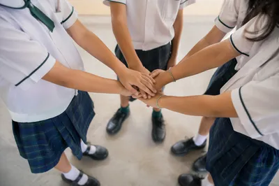 Children Stacking Hands in School Teamwork