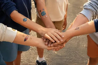 Children Stacking Hands in Teamwork Circle