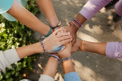 Children Stacking Hands in Sunlit Teamwork