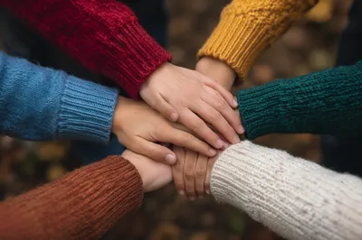 Children Stacking Hands in Teamwork Circle
