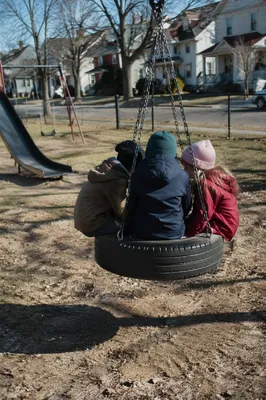 Children Playing on Neighborhood Playground Swing