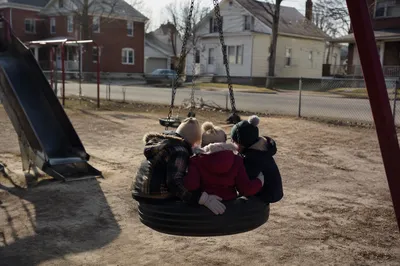 Children Playing on Neighborhood Playground Swing