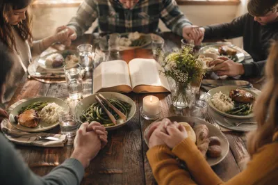 Christian Family Dinner Prayer at Rustic Table