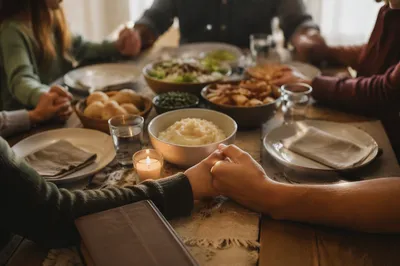 Christian Family Dinner Prayer Around Rustic Table
