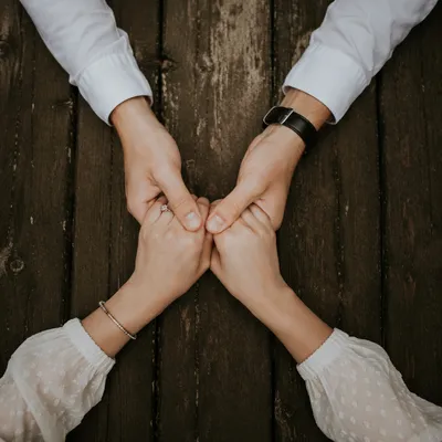 Couple Praying Hand in Hand on Rustic Wood