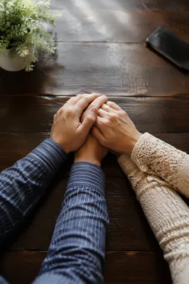 Couple Praying Hand in Hand at Table