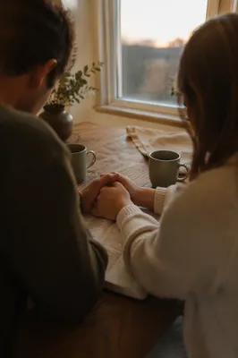 Couple Praying at Sunrise Kitchen Table
