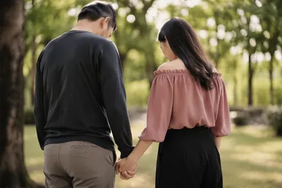 Couple Praying Hand in Hand in Park