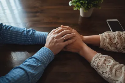 Couple Praying Hand in Hand at Table