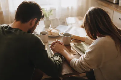 Couple Praying Together at Breakfast Table