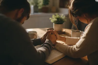 Couple Praying Hand in Hand at Breakfast