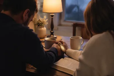 Couple Praying Together at Dawn Kitchen Table