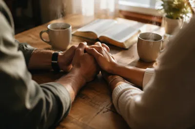 Couple Praying Together at Morning Table