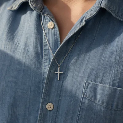 Silver Cross Pendant on Denim Shirt