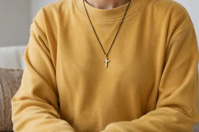 Cross Necklace on Mustard Knit Sweatshirt