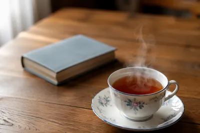 Steaming Floral Teacup on Wooden Table