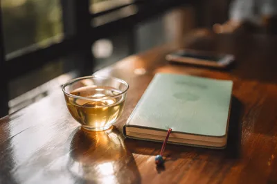 Tea and Booklet on Wooden Table