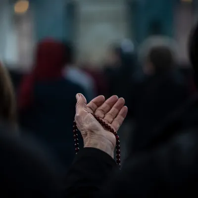Elderly Hand Holding Rosary in Prayer