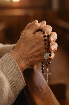 Elderly Hands Praying With Wooden Rosary
