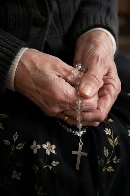 Elderly Hands Holding Rosary in Prayer