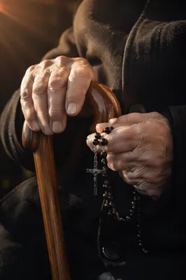 Elderly Hands Holding Rosary in Prayer