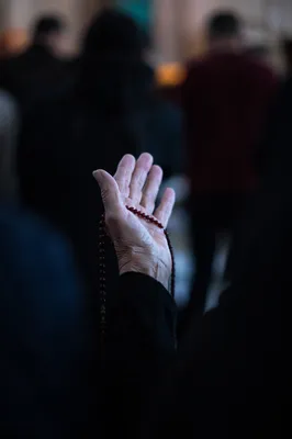 Elderly Hands Holding Rosary in Prayer