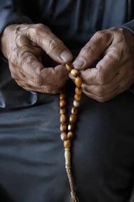 Elderly Hands Holding Rosary Beads in Prayer