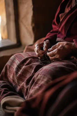 Elderly Hands Holding Rosary in Prayer