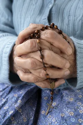 Elderly Hands Holding Rosary in Prayer