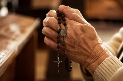 Elderly Hands Holding Rosary in Prayer