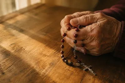 Elderly Hands Holding Rosary in Prayer