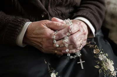 Elderly Hands Holding Rosary in Prayer