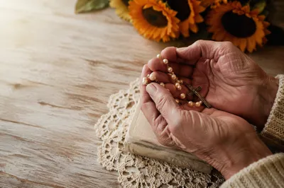 Elderly Hands Holding Rosary in Prayer