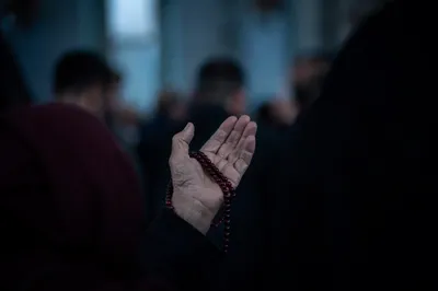 Elderly Hand Holding Rosary in Prayer