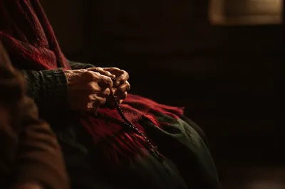 Elderly Hands Holding Rosary in Prayer