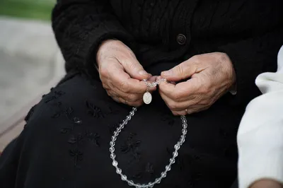 Elderly Hands Holding Rosary in Quiet Prayer