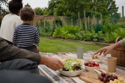 Family Picnic on Blanket in Garden Park