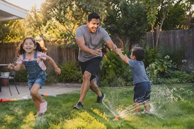 Father Playing Tag with Children Backyard
