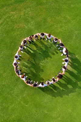 Aerial Friends Circle Hug on Green Lawn