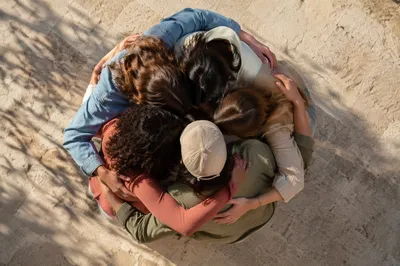 Overhead Friends Group Hug in Sunlit Courtyard