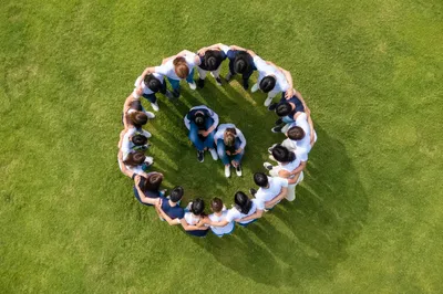 Overhead Friends Group Hug on Green Lawn