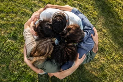 Overhead Friends Group Hug on Sunny Grass